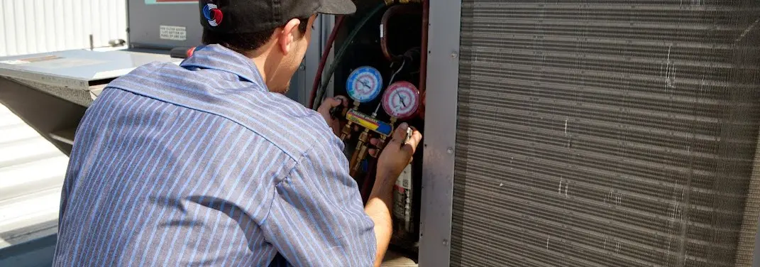 HVAC technician servicing a condenser unit in Chardon