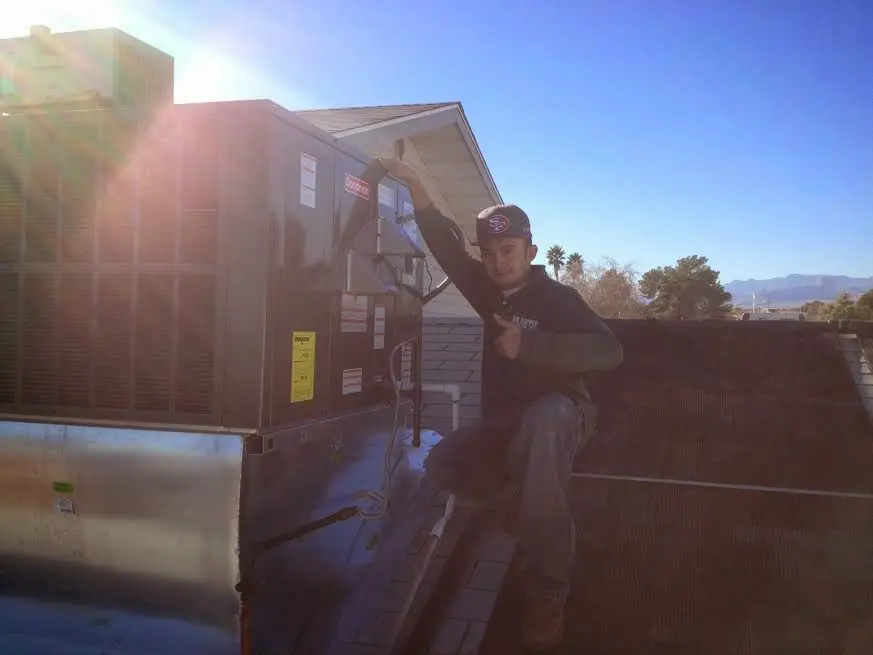 HVAC technician performing HVAC Inspection on a rooftop unit in Chardon